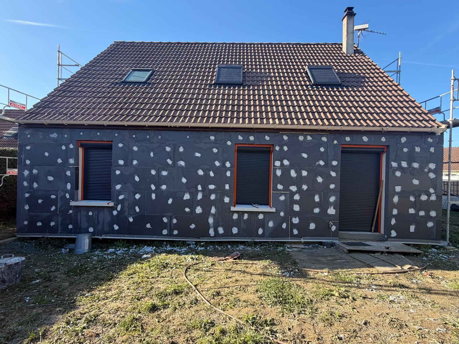 Pendant chantier : pose des plaques de polystyrène pour ITE