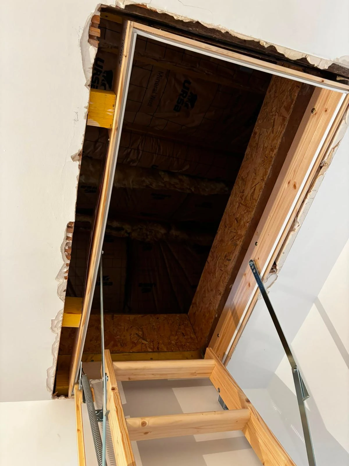 Trappe d’accès aux combles ouverte avec escalier escamotable en bois