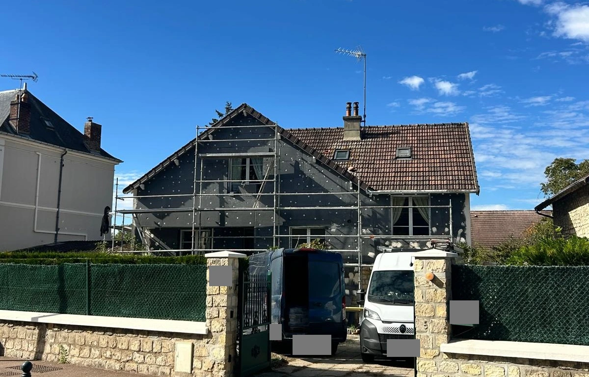 Pendant les travaux : panneaux de PSE gris posés sur la façade.